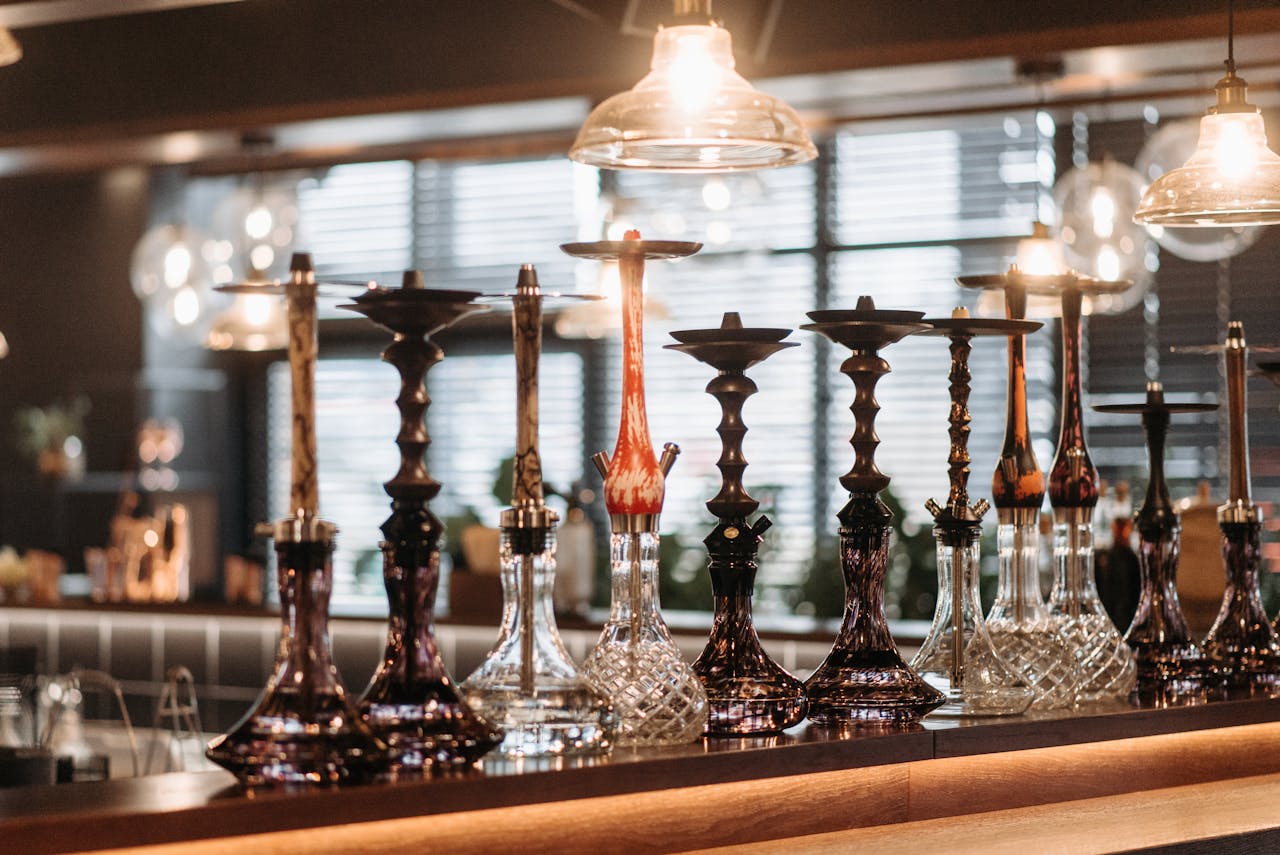 A stylish array of hookahs displayed on a bar counter with ambient lighting.