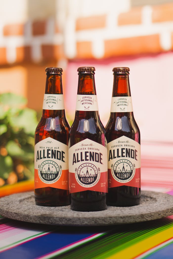 Services Three Allende craft beer bottles on colorful table in Mexico, perfect for food and drink themes.